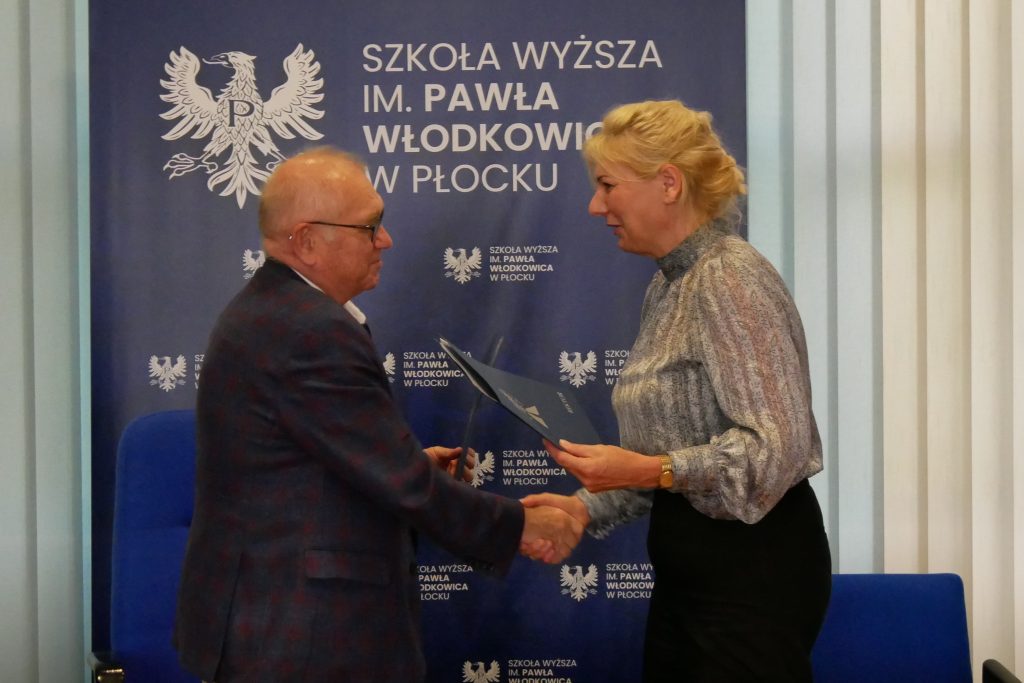 Rektor Kruszewski oraz Renata Nych wymieniają się podpisanymi dokumentami