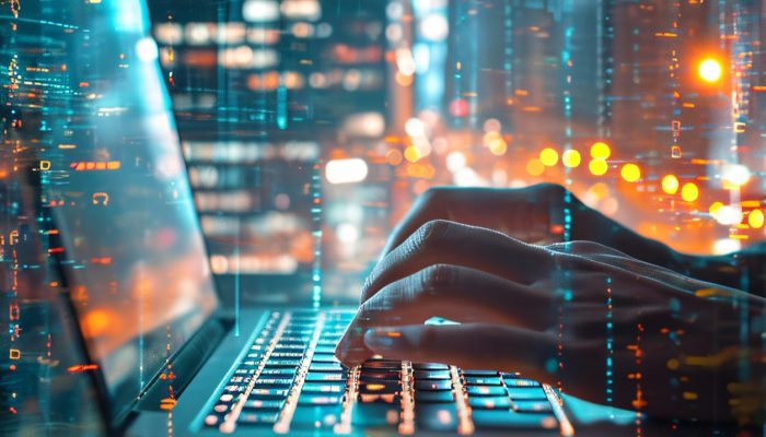 Dłonie osoby piszącej na klawiaturze laptopa